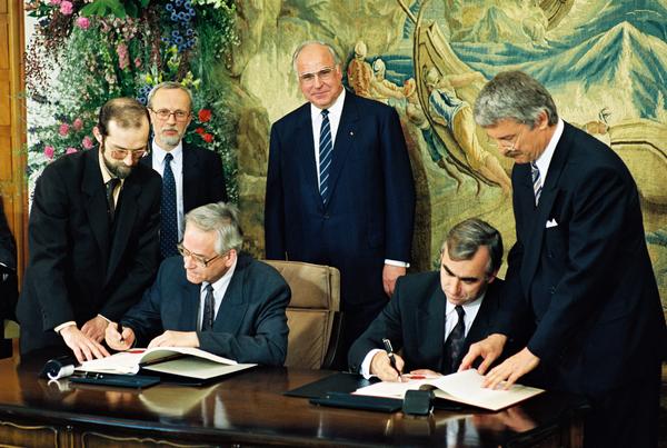 Theo Waigel und Walter Romberg unterschreiben im Beisein von Kohl und de Maiziére einen Vertrag.